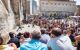 Crowds stand in circles around performers in the square in front of the Palace of the Pope