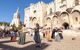 Performers dressed in traditional dress perform to a crowd outside Popes Palace