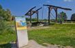 view of an old wooden bridge, with a van gogh information board in the foreground