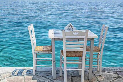 Table for lunch by waterside in a greek tavern of Stegna Kozas on Rhodes