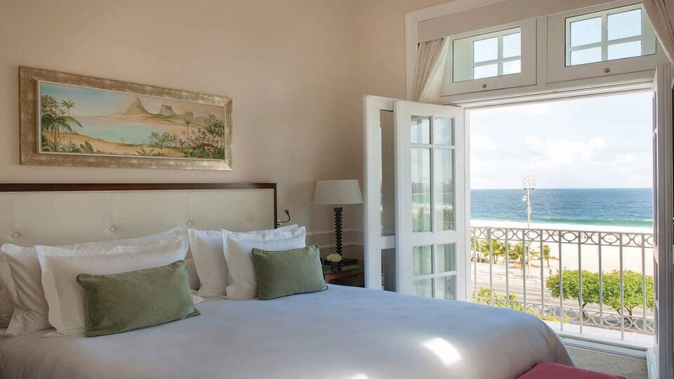 Double bedroom with open french door onto sea