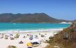 Busy beach with headland in background