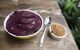 Bowl of purple paste with spoon and nuts
