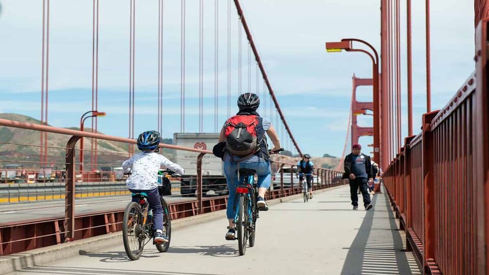 Parent and child cycling over the Golden Gate Bridge, San Francisco to Sausalito