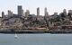 A sailboat sails in front of a beautiful San Francisco skyline.