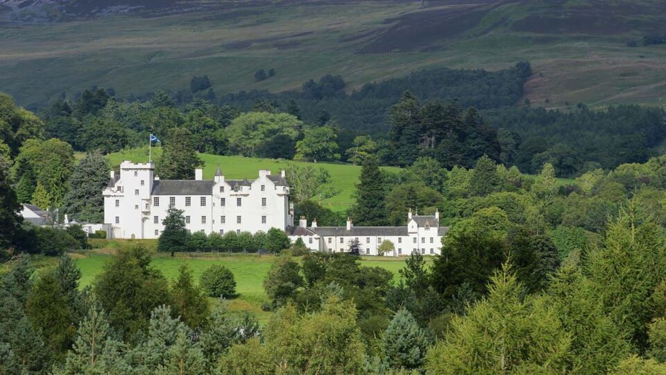 External view of the lovely white castle set into green hills