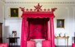 An ornate and bright pink four-poster bed