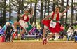 Two young girls doing a Highland dance jumping in the air