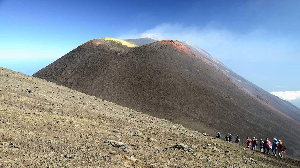 tourists climbing up to Summit of Volcano Mount Etna, Sicily, Italy