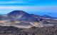 Active Volcano Etna on Sicily, Italy. Mountain and Hills Landscape with burned black magma earth. Black ground and blue sky