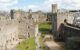 People exploring the ruins of Caernarfon castle built in the 13th century by Edward the first and is now a world heritage site