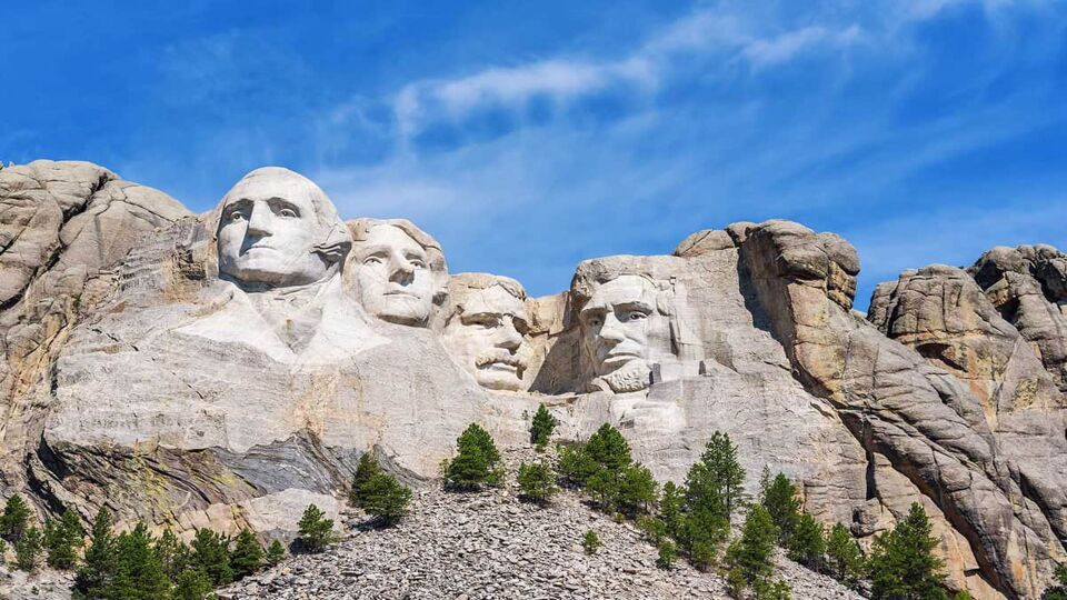 Four stone heads carved into the cliff