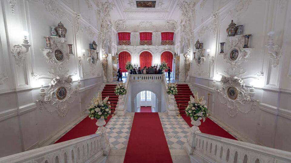 Staircase in foyer with red carpet and white walls