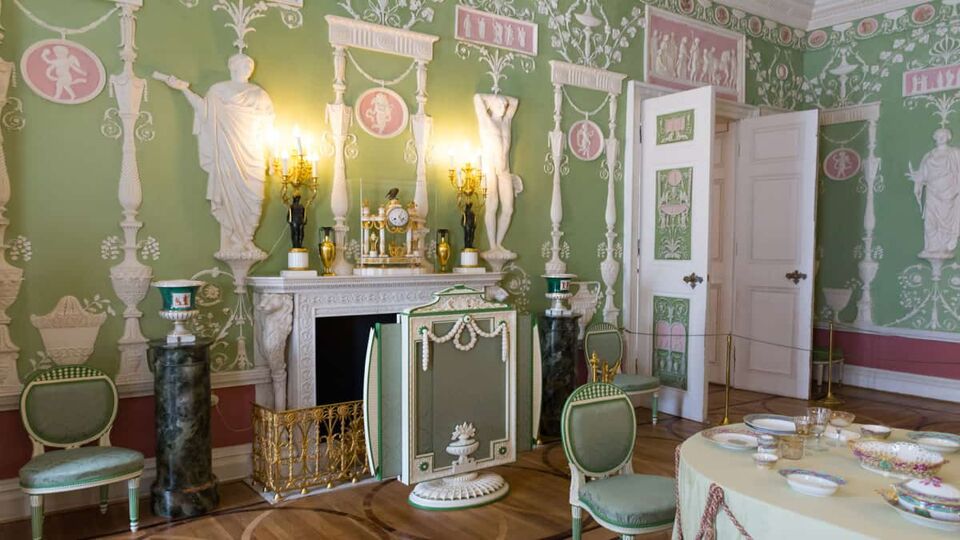 Pale green room with high ceilings and ornate panelling