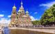 Large cathedral with domed towers by the canal