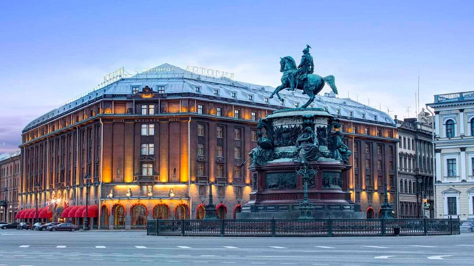 Red brick hotel in square by bronze statue