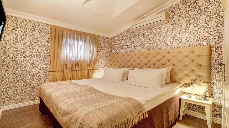Double bedroom with patterned cream wallpaper