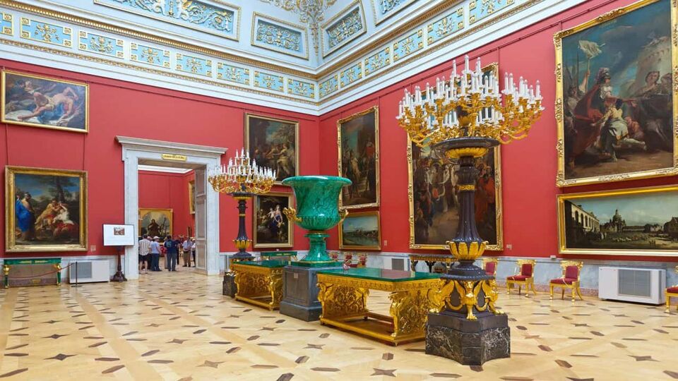 Red gallery room with paintings