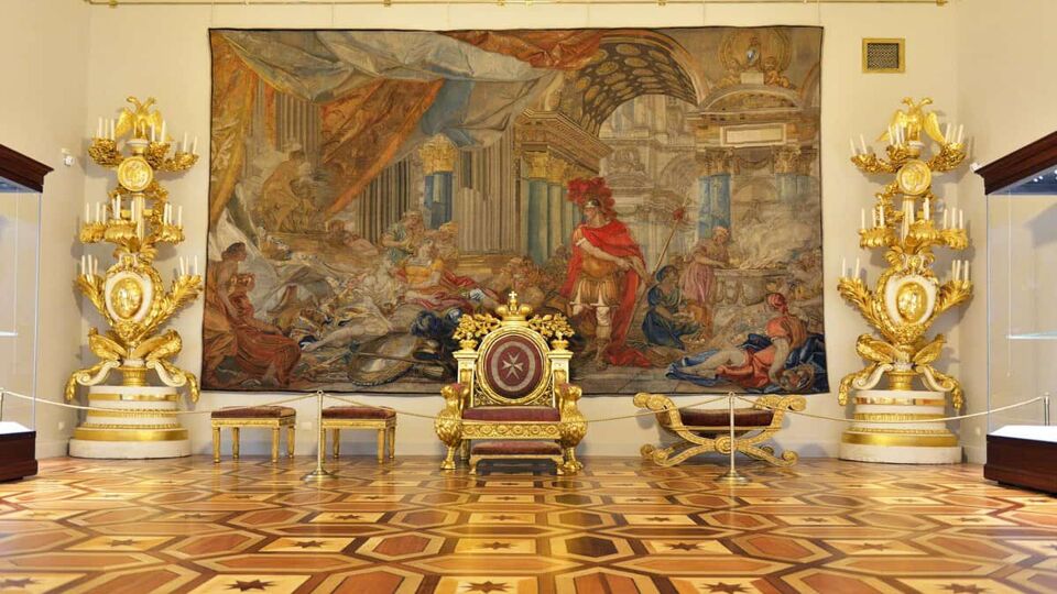 Gallery room with gold earns either side of large painting