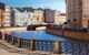 Canal through colourful city buildings and bridge