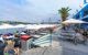 Many benches and umbrella shades on the harbour on a sunny day.