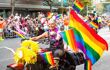 A motorbike dressed as a donkey carrying lots of LGBTQ+ flags.