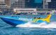 A speed boat driving fast through Sydney harbour.