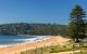 An idyllic beach with greenery in the background.