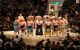 12 fighters arrayed in a circle around the ring in regalia