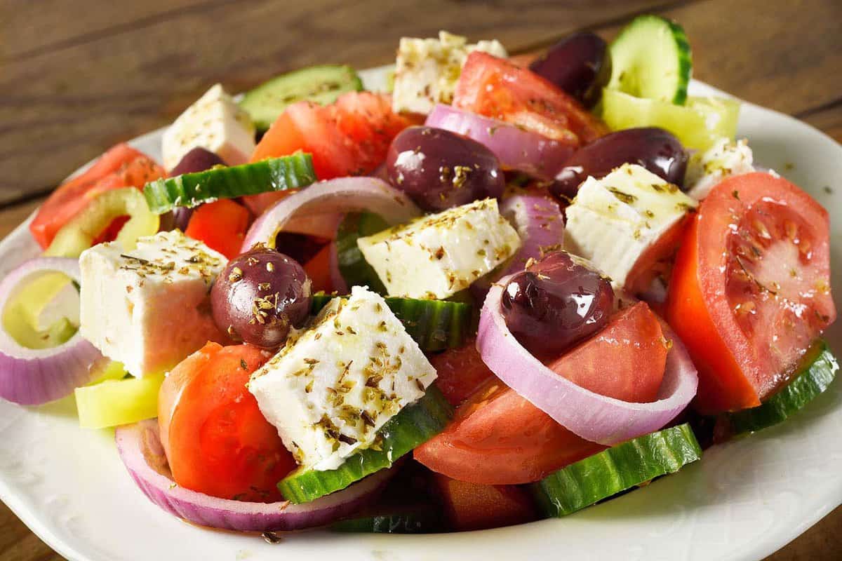 close up of a bowl of Choriatiki, or Greek Salad - tomatoes, onions, olives, cucumber and feta cheese