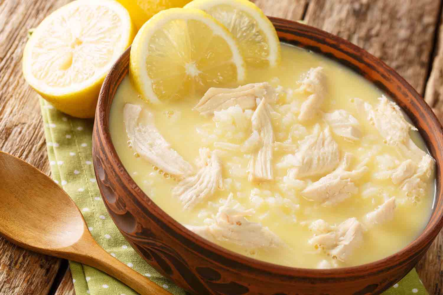 close up of a bowl of Kotosoupa Avgolemono - chicken pieces and lemon