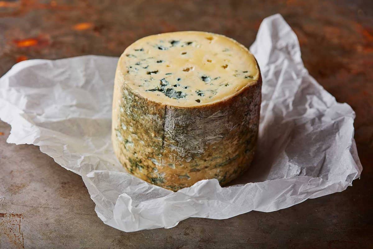 large round blue stilton cheese on a table