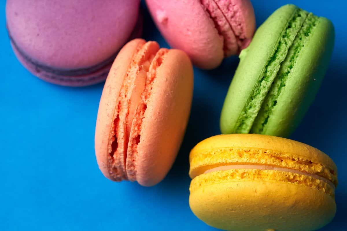Close-up of macarons cakes of different colors in blue background.