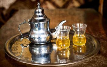 Mint tea - traditional foods you must try in Morocco. Set of arabic nana mint tea with metal tea pot and glasses