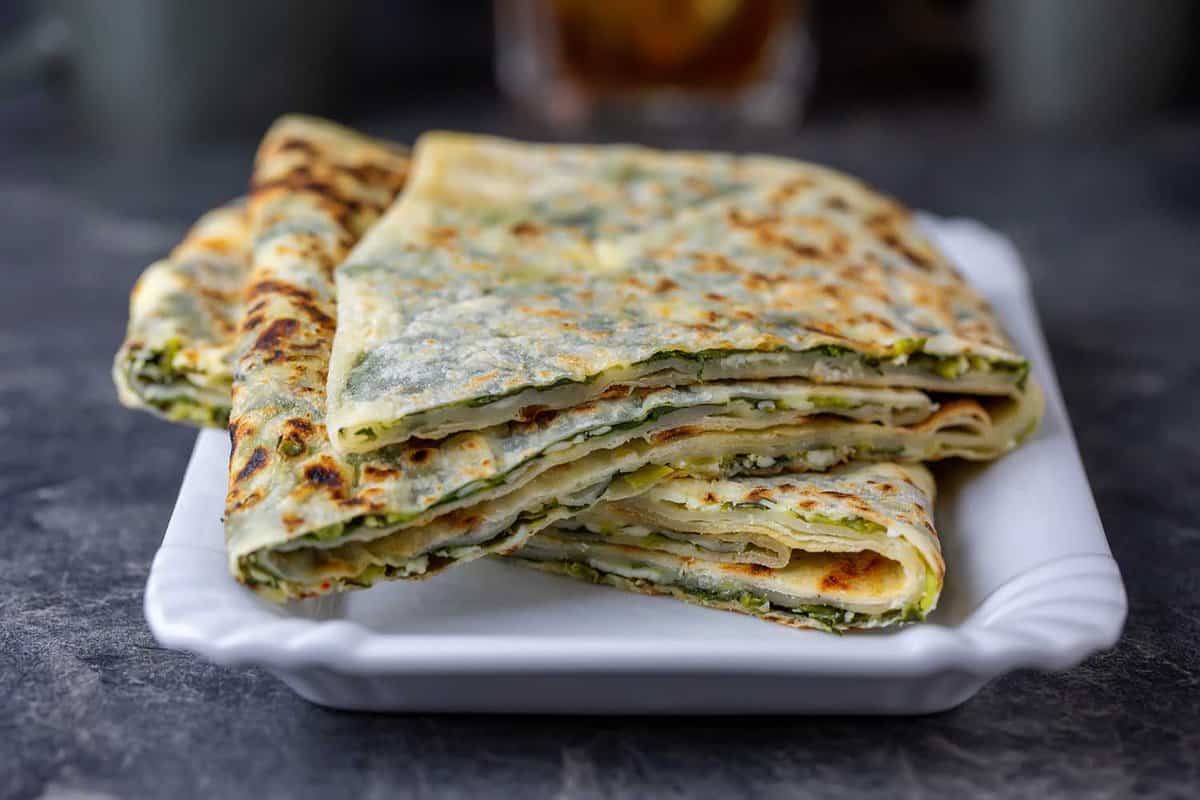Traditional Turkish food gozleme with cheese and spinach. Turkish pancake gozleme concept on the dark background.