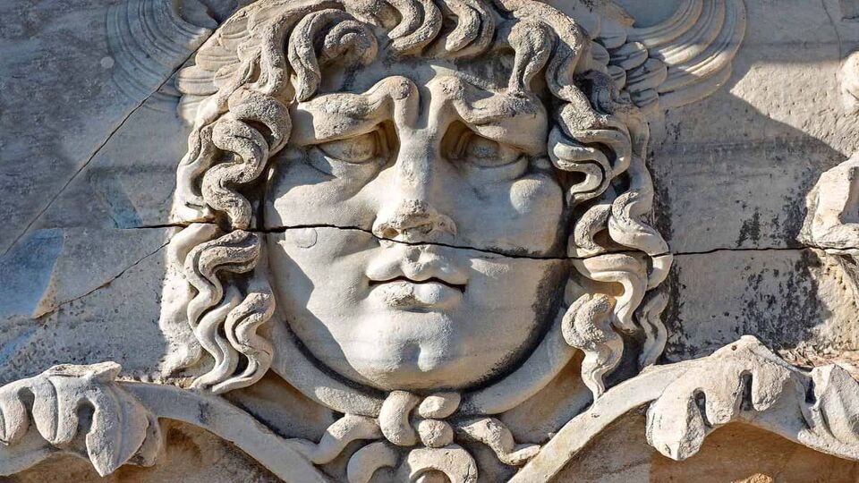 Ancient sculpture of the head of Medusa in the temple ruins