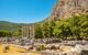 Ionic columns of the Temple of Athena surrounded by mountains and greenery