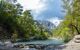 Emerald lake with calm water on the background of mountains in the summer sunny day