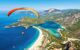 Person paragliding over the turquoise sea