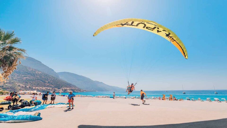 Landing of numerous paragliders on the beach promenade in the resort town of Oludeniz