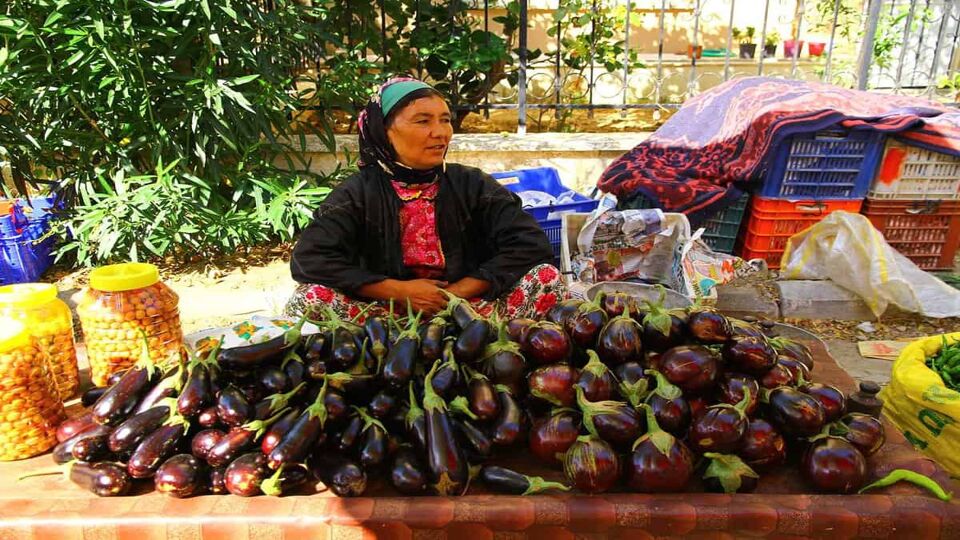 A woman selling aubergines at the local food market