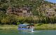 The panoramic view of rock tombs at Kaunos with a boat on the river