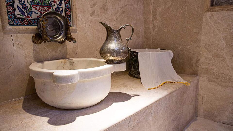 Marble sink with metal jug in a traditional Turkish bath