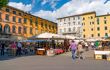 Tourists and residents fill a busy market in the Tuscan town of Lucca