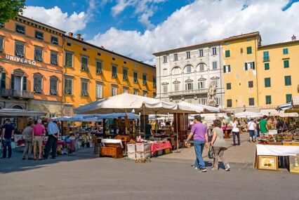 Tourists and residents fill a busy market in the Tuscan town of Lucca