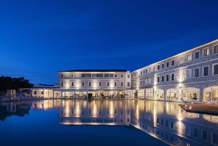 Large outdoor thermal pool lit up at night