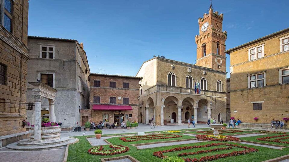 Idyllic square with fountain, town hall and a small coffee house in Pienza.