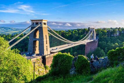 Side view of the Clifton Suspension Bridge spanning river and green valley