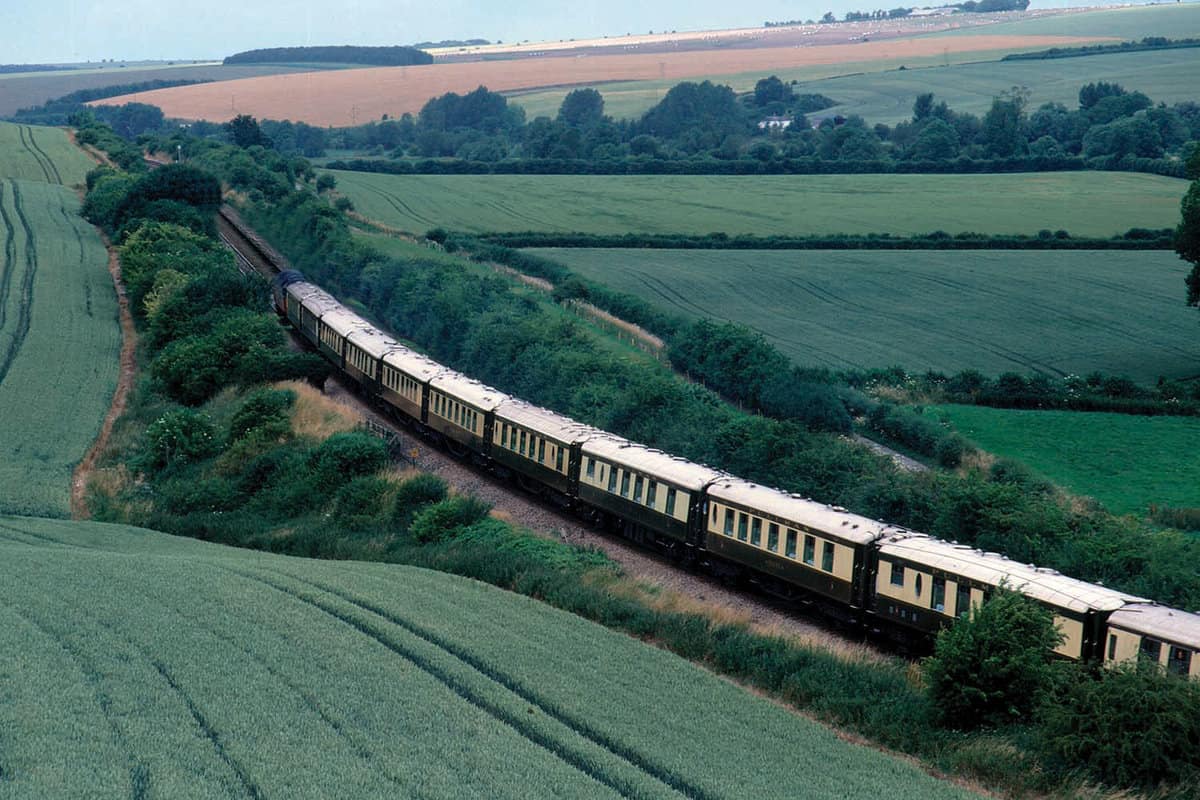 Aerial view of the train in the countryside, with distinctive yellow and brown carriages