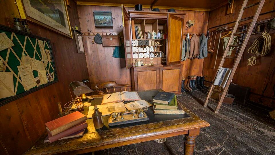 A wooden old room with lots of horse equipment around